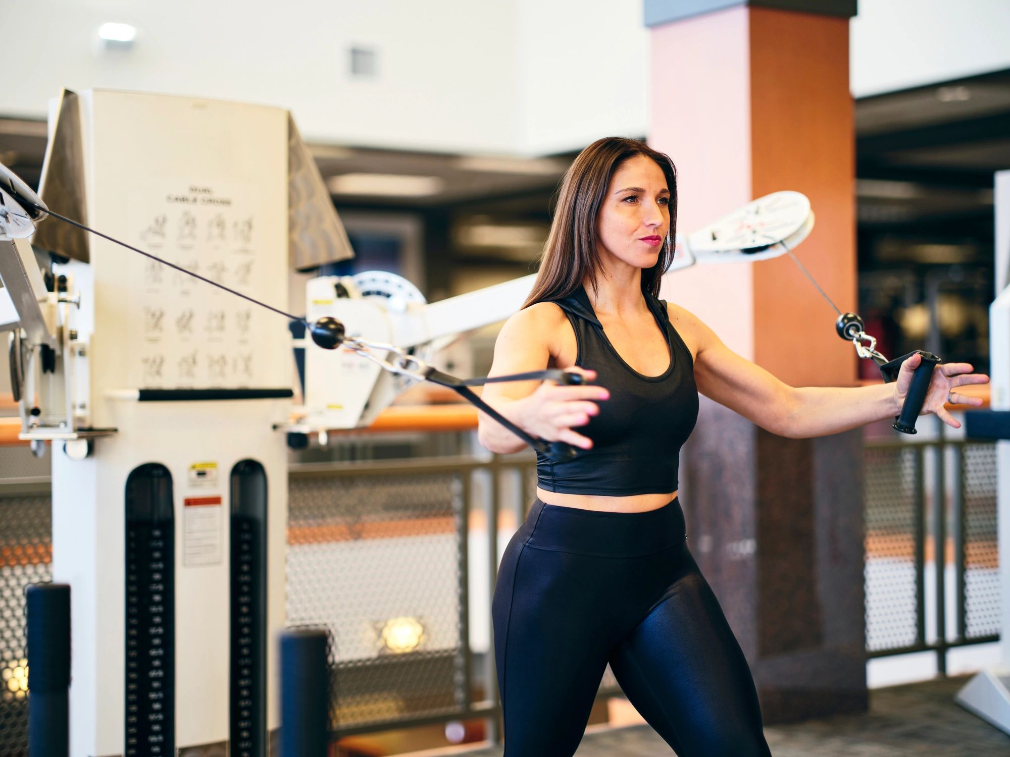 Woman using a strength training machine in a gym