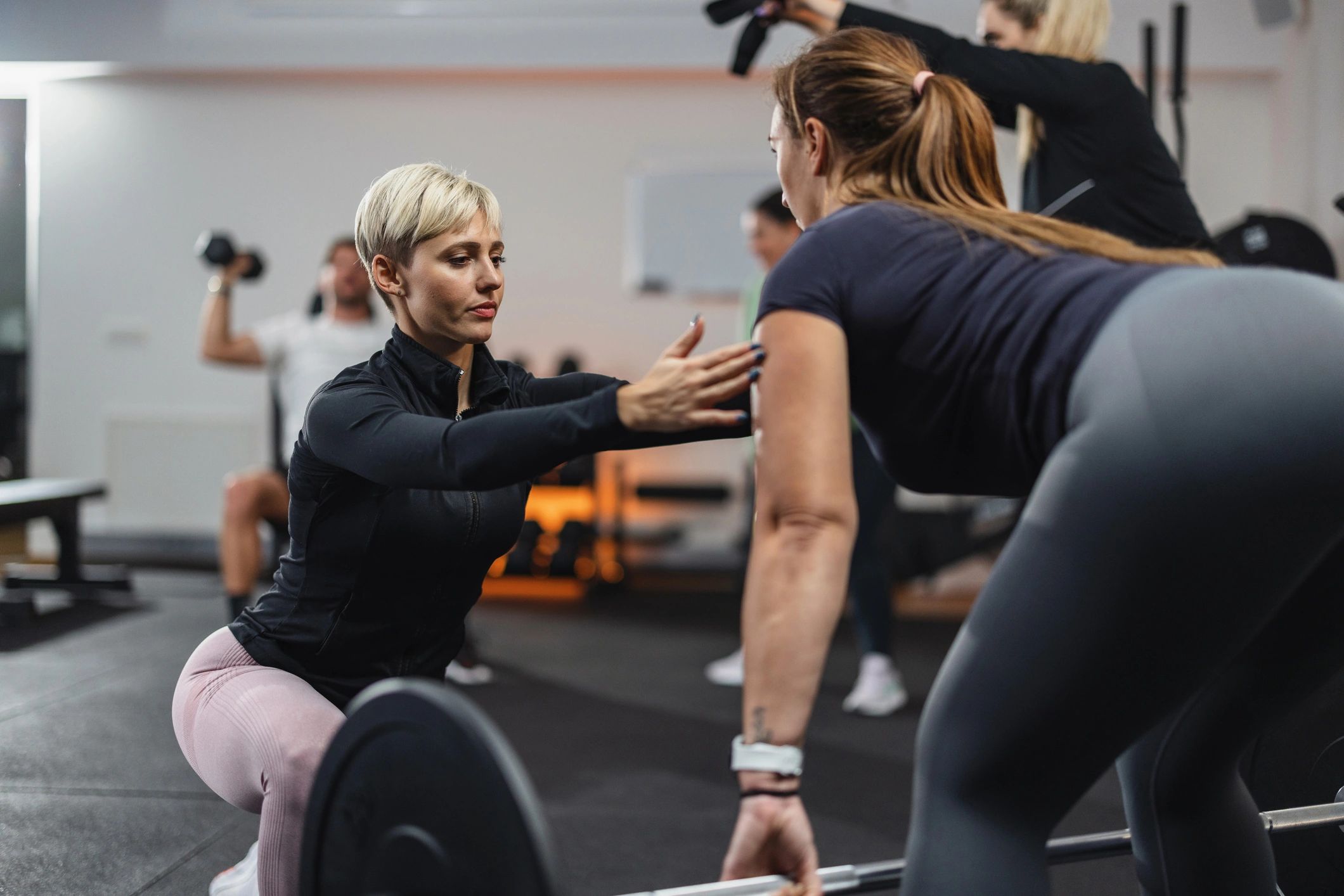 Personal trainer coaching a client during a deadlift