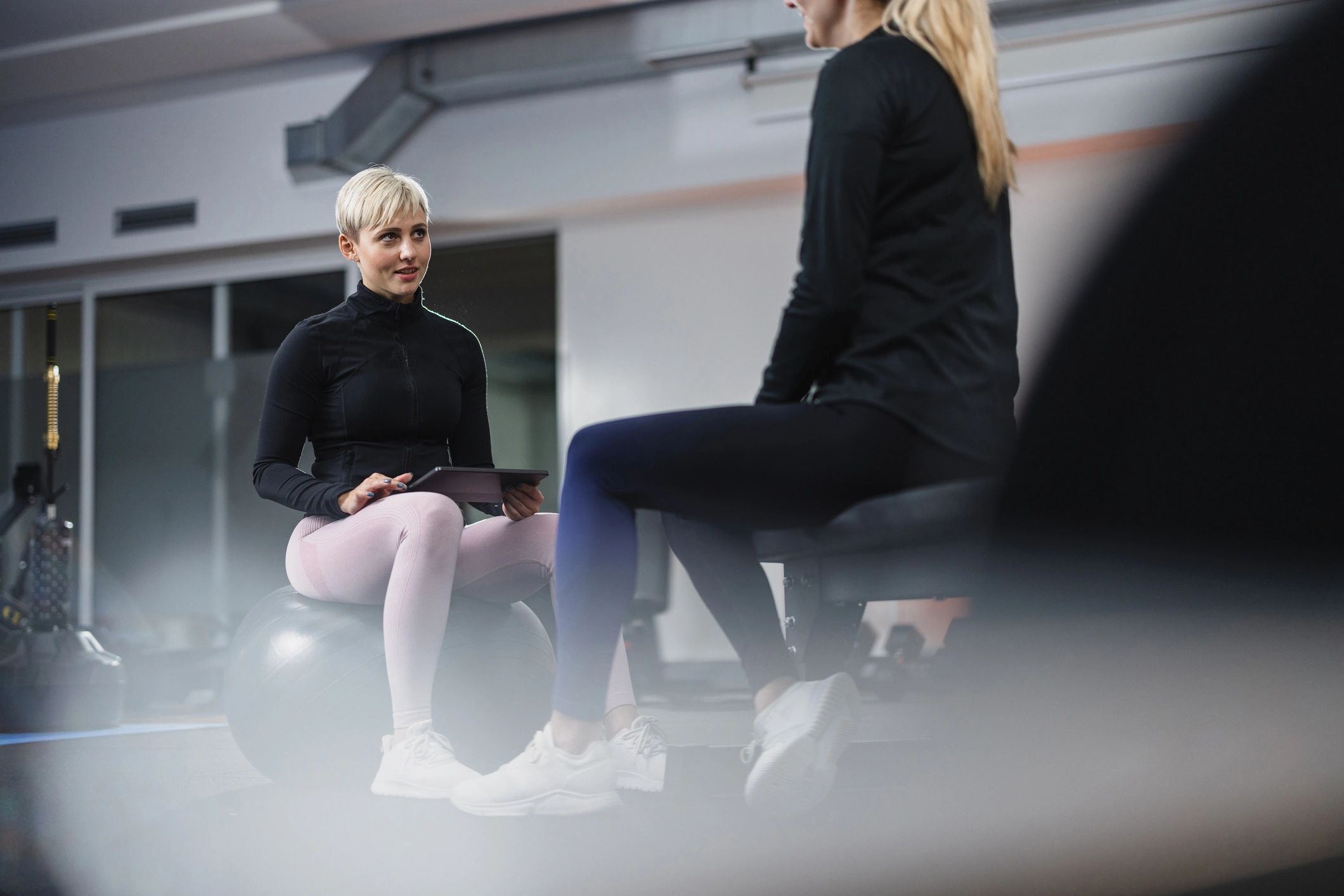 Trainer discussing a workout plan with a client in a gym