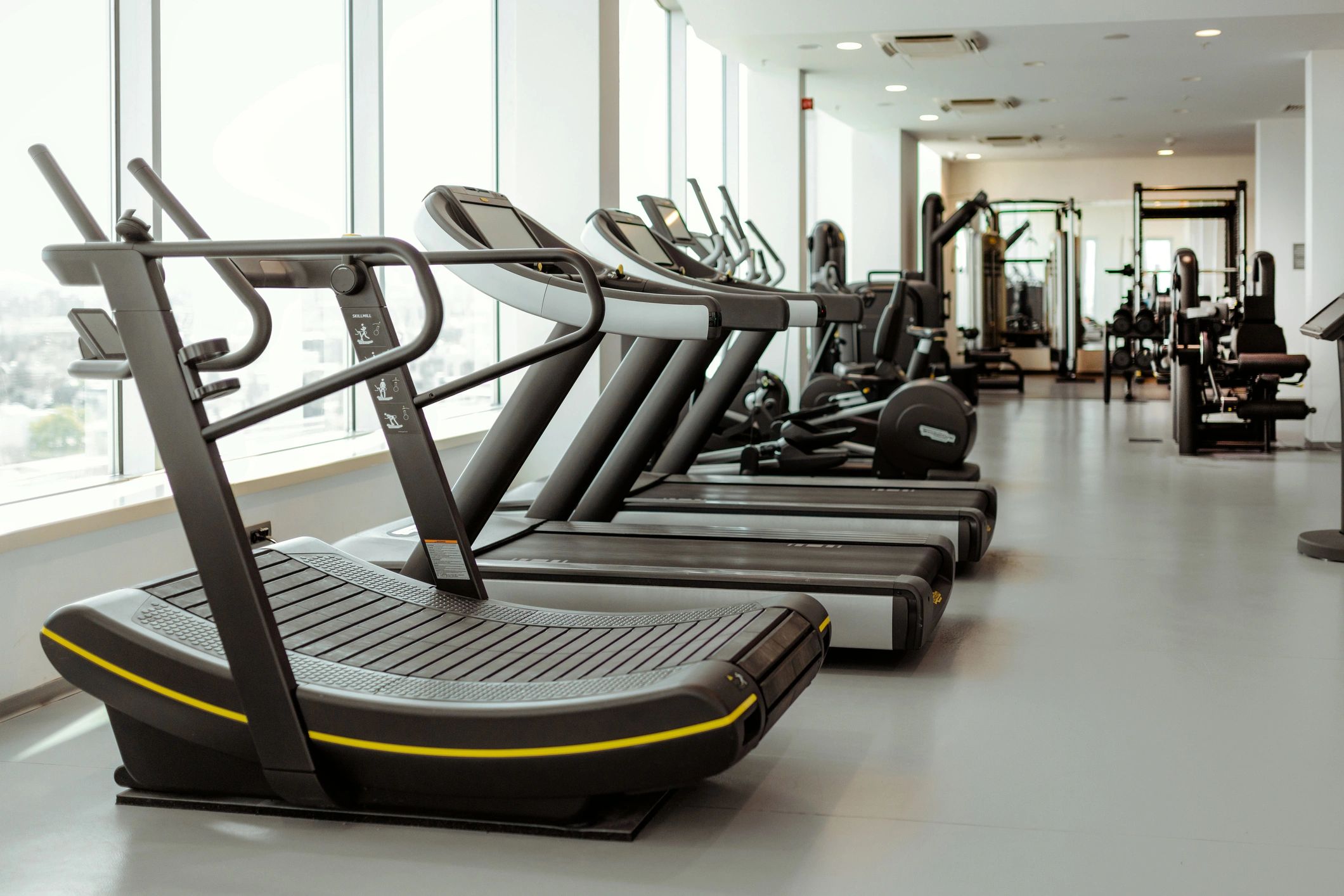 Modern gym cardio equipment by a window